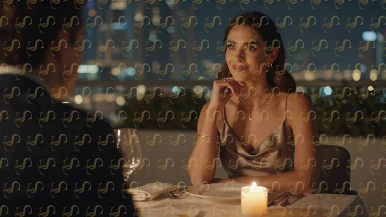 A brunette woman in a silk dress at a quiet rooftop dinner, candlelight illuminating her poised expression.